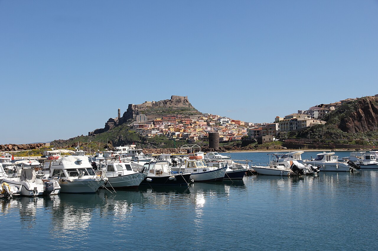 Castelsardo z portu: domy wspinają się na skalny cypel pod zamkiem rodu Doria.